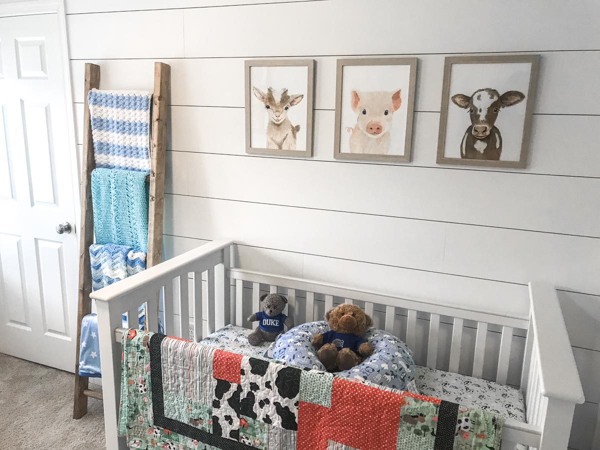 DIY shiplap wall with pictures, ladder and crib