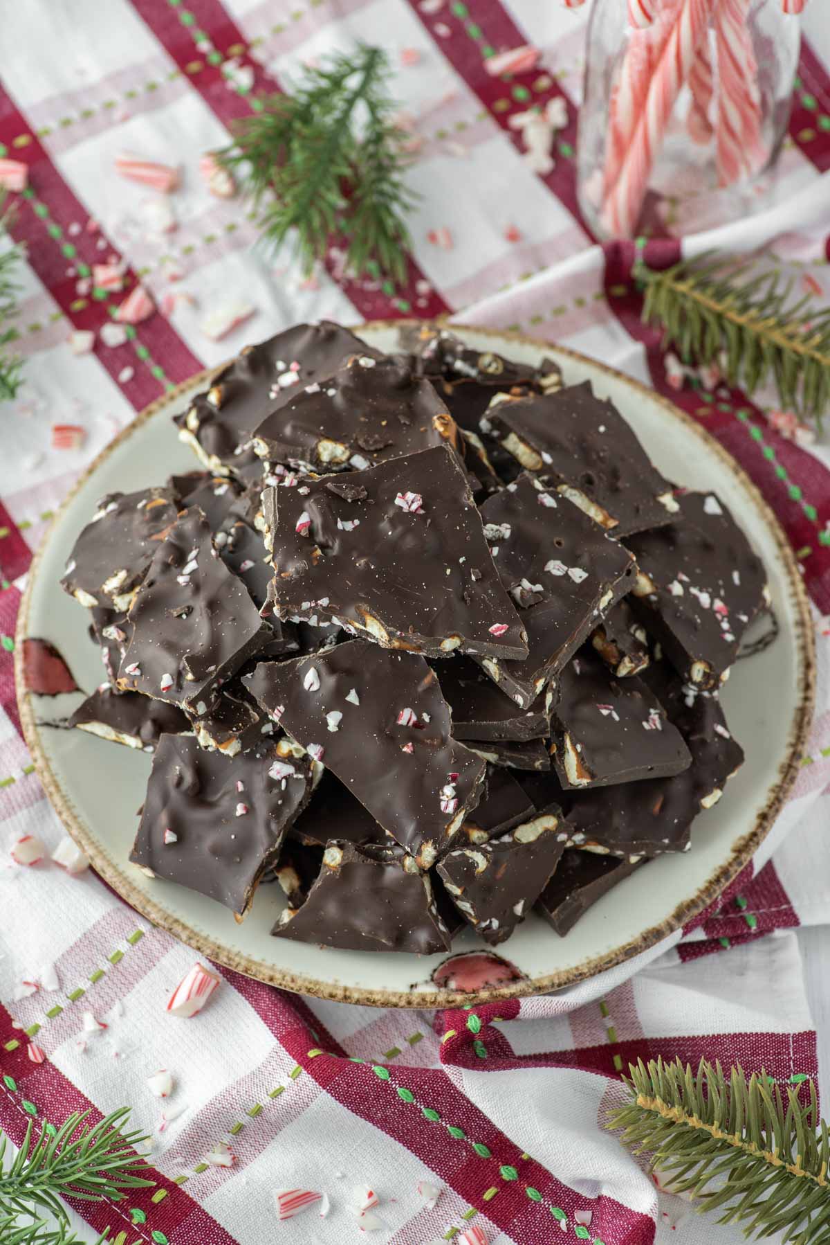 peppermint pretzel bark stacked on plate on dish towel