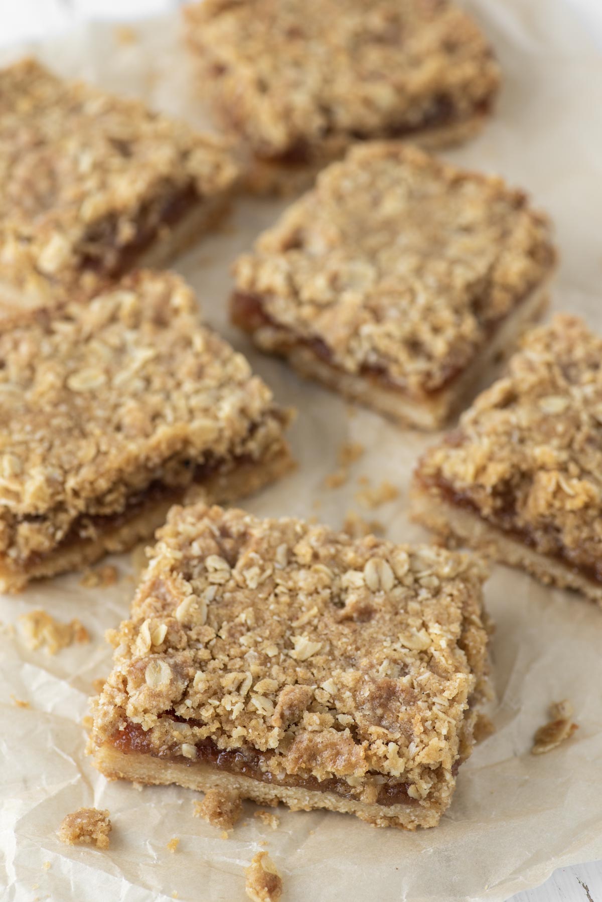 cut jam bars with crumble topping on parchment paper