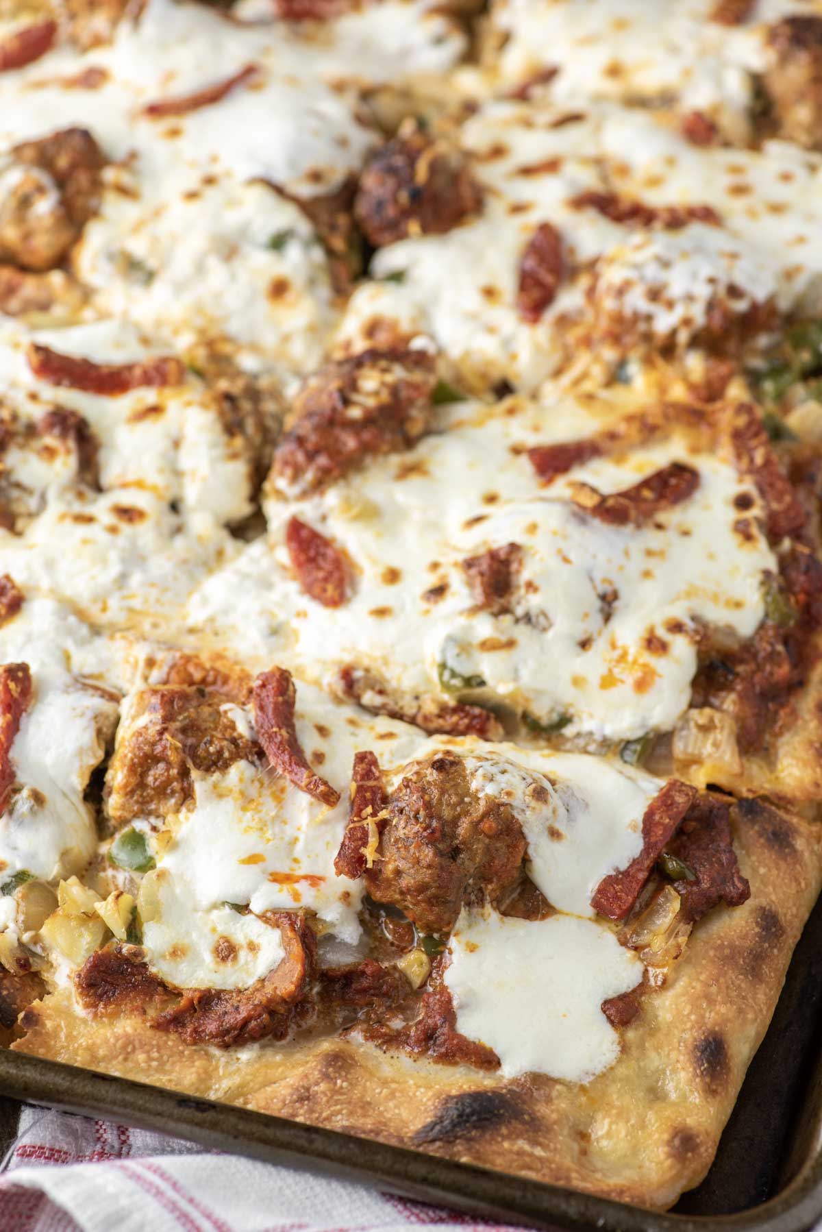 Sicilian-style pizza in sheet pan that is cut