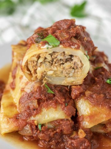 stuffed cabbage roll cut in half and stacked on two cabbage rolls