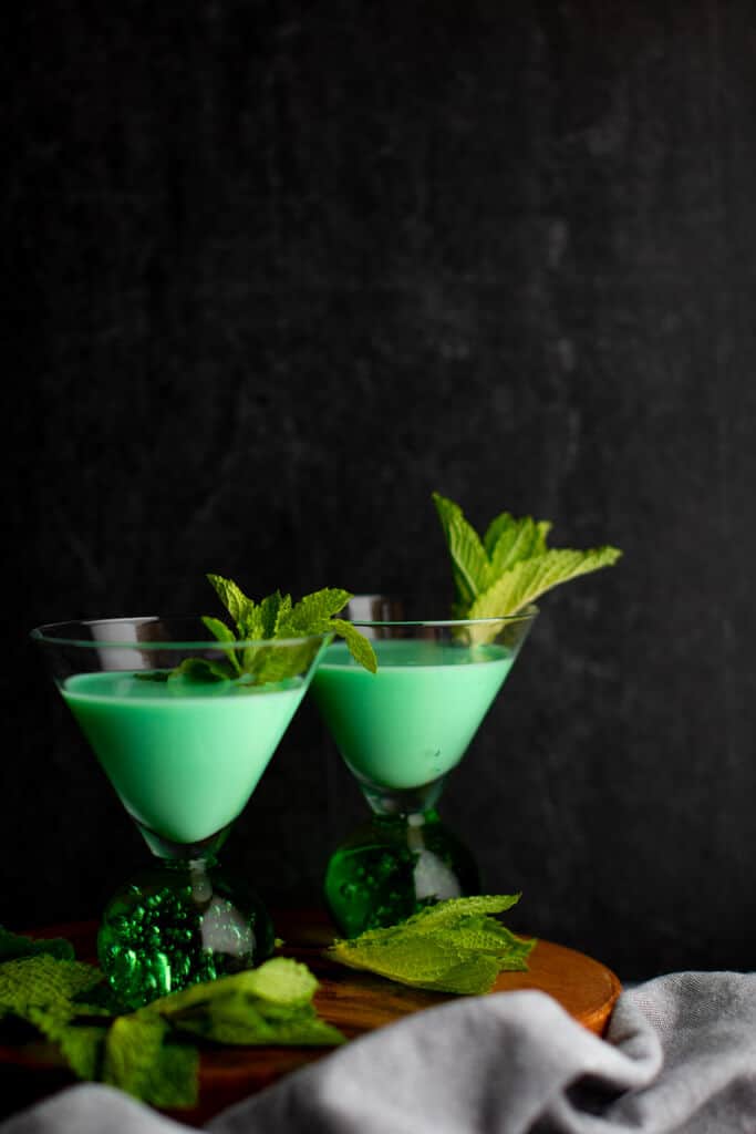 two grasshopper cocktails on wood board