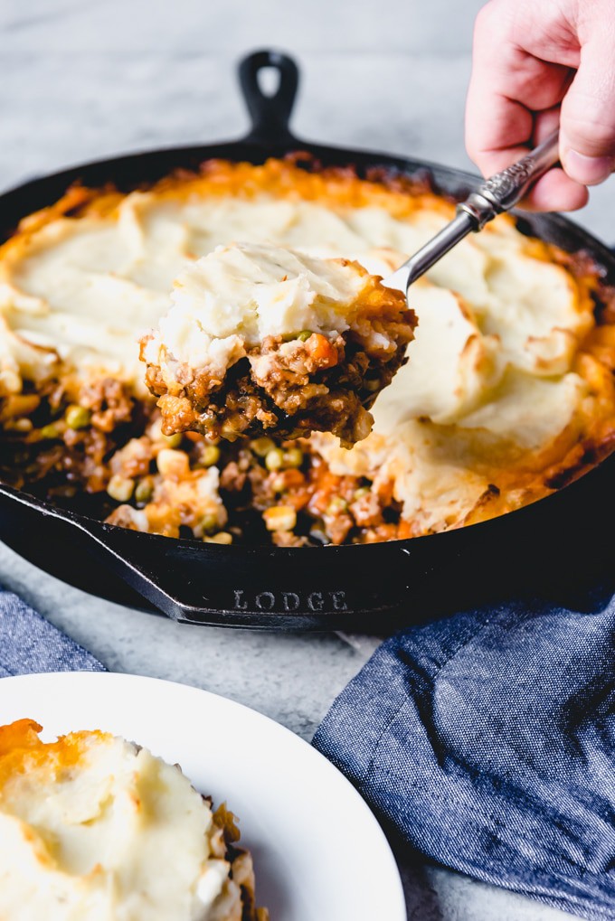 spoon lifting out shepherd's pie from skillet