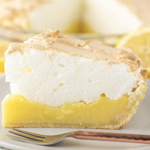 slice of lemon meringue pie with fork on plate