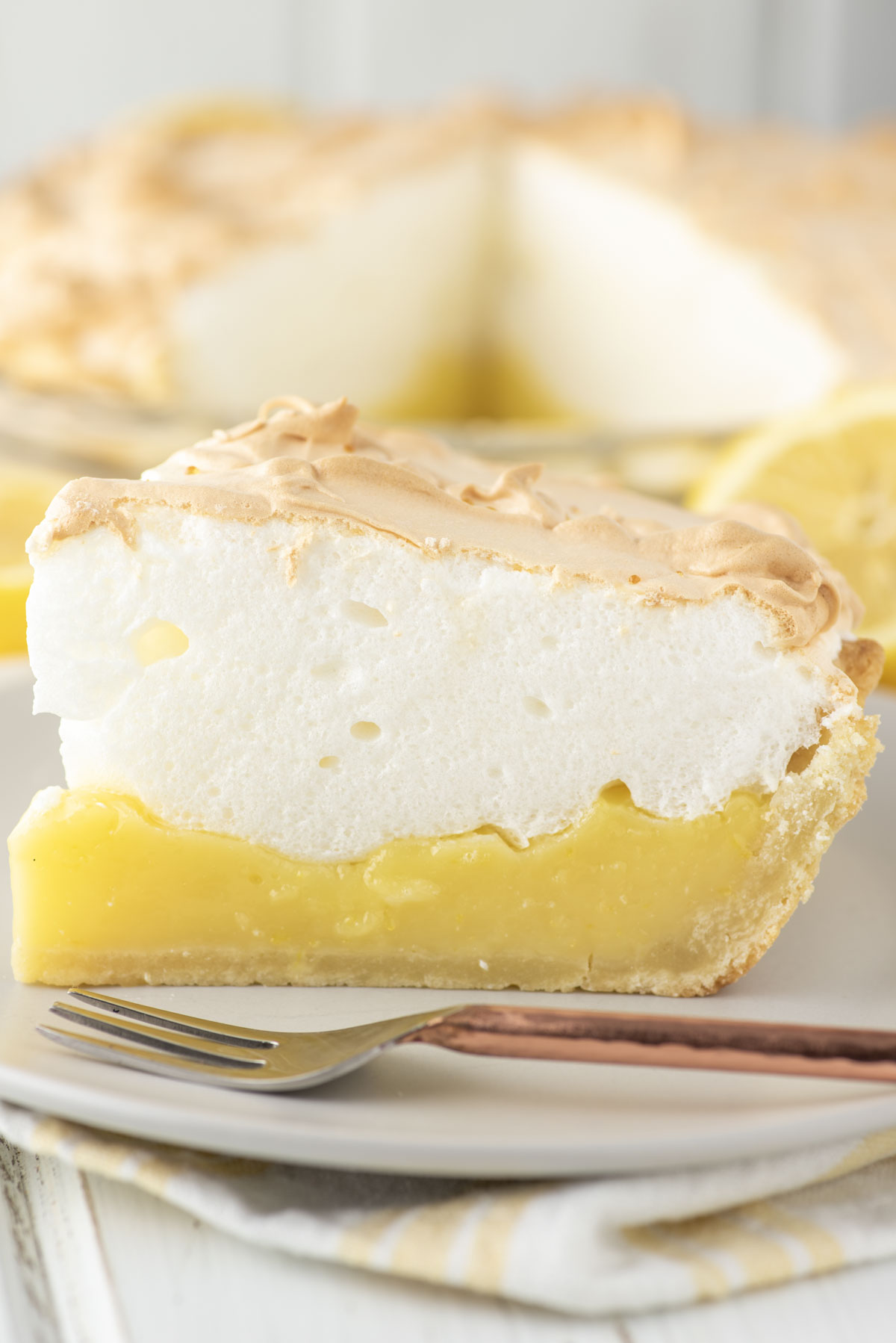 slice of lemon meringue pie with fork on plate