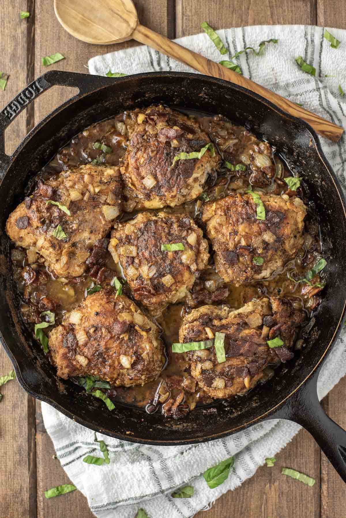 overhead shot of chicken with white wine sauce in cast iron skillet