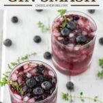 two blueberry cocktails in glasses with fresh blueberries