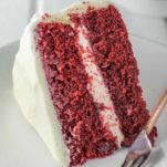 slice of red velvet cake on white plate with fork