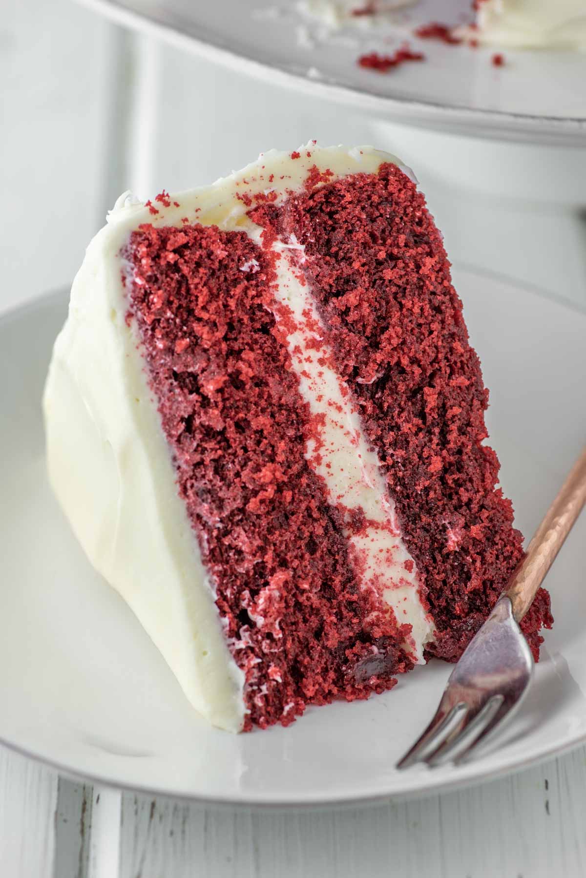 slice of red velvet cake on white plate with fork