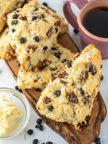 blueberry scones on wood board with cup of coffee