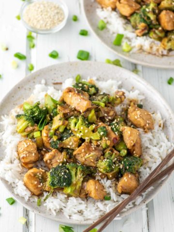 two plates of chicken and broccoli stir fry on jasmine rice
