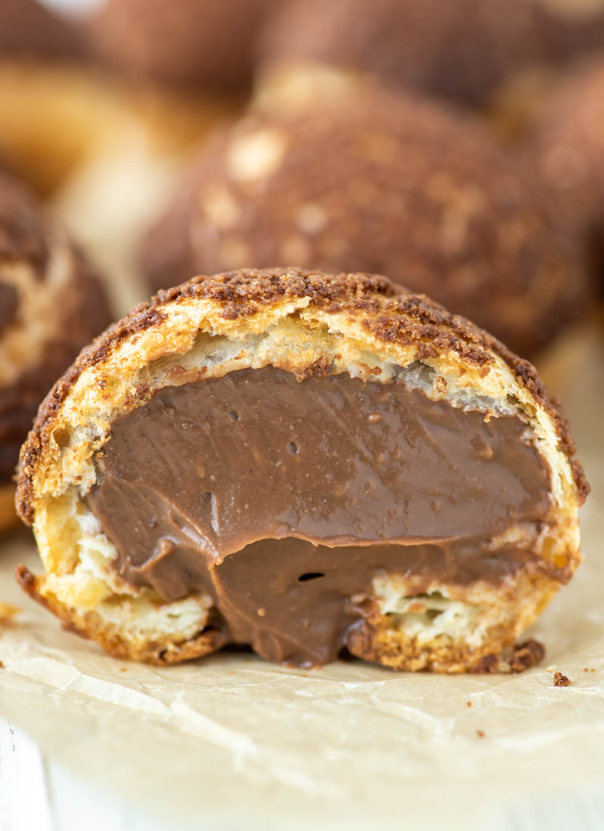 chocolate cream puff cut in half with chocolate pastry cream oozing out