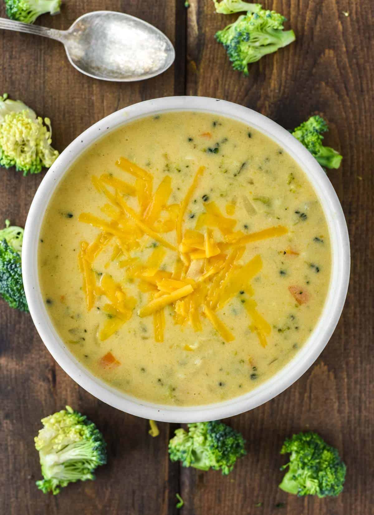 overhead shot of broccoli and cheese soup in speckled bowl