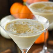 two glasses of pumpkin piemartinis with pumpkins in the background