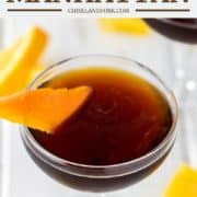 coupe glass filled with Black Manhattan and orange peel