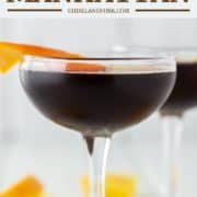 Black Manhattan with orange peel in coupe glass