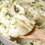 wooden spoon lifting out mashed potatoes from bowl