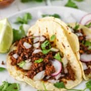 two chorizo tacos on white plate