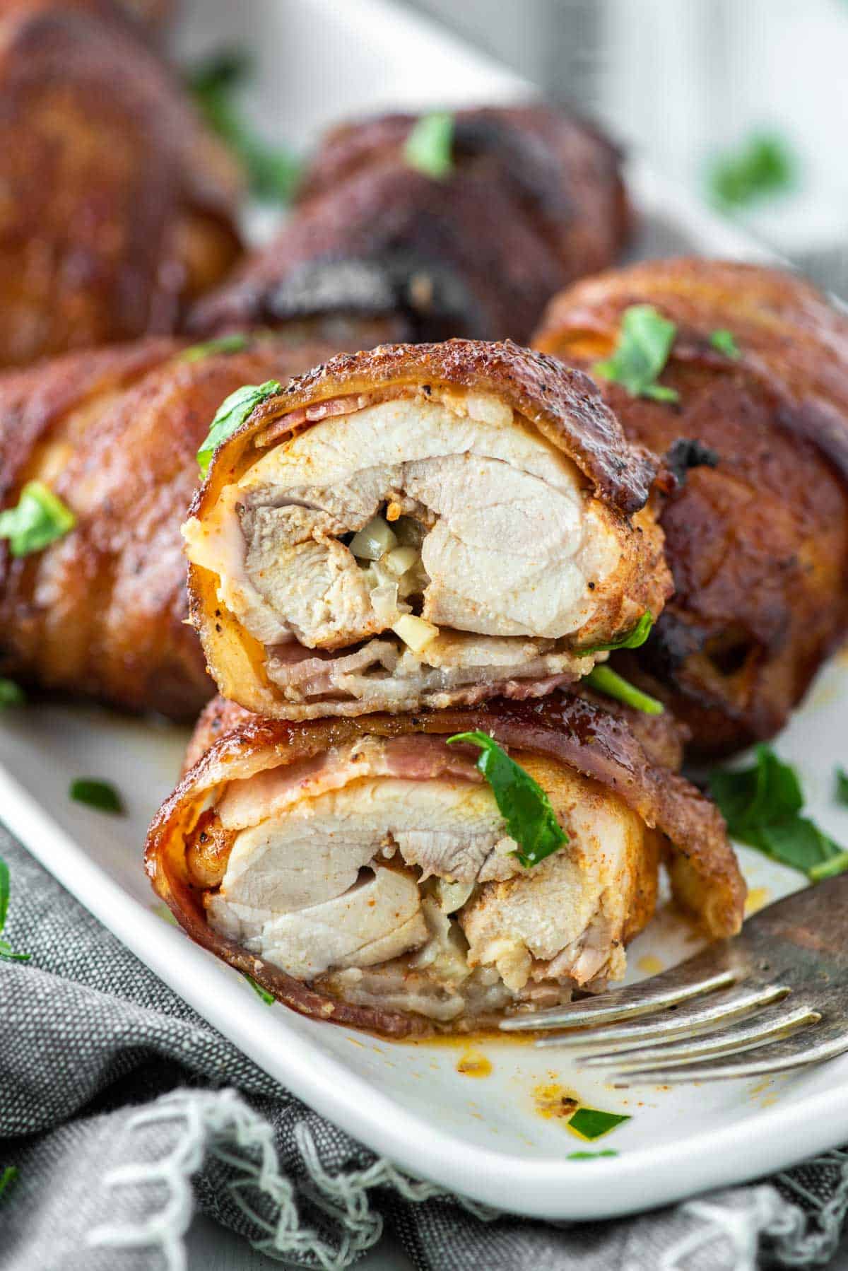 bacon wrapped chicken thigh cut in half stacked on top of each other
