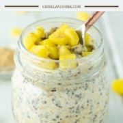 spoon dipped in glass jar of mango overnight oats