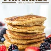 5 stacked oat flour pancakes on plate with fruit