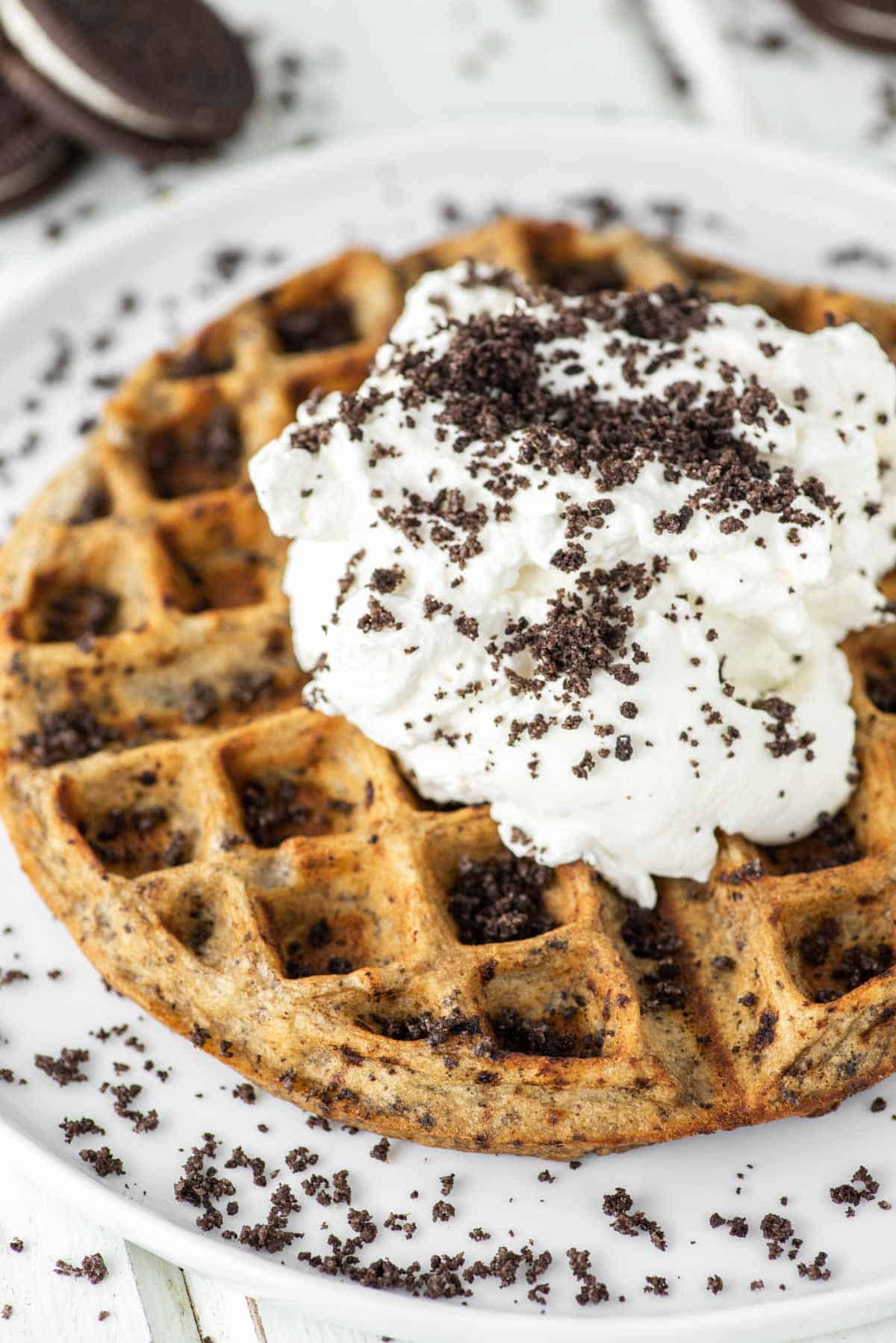 Oreo waffle with whipped cream on white plate