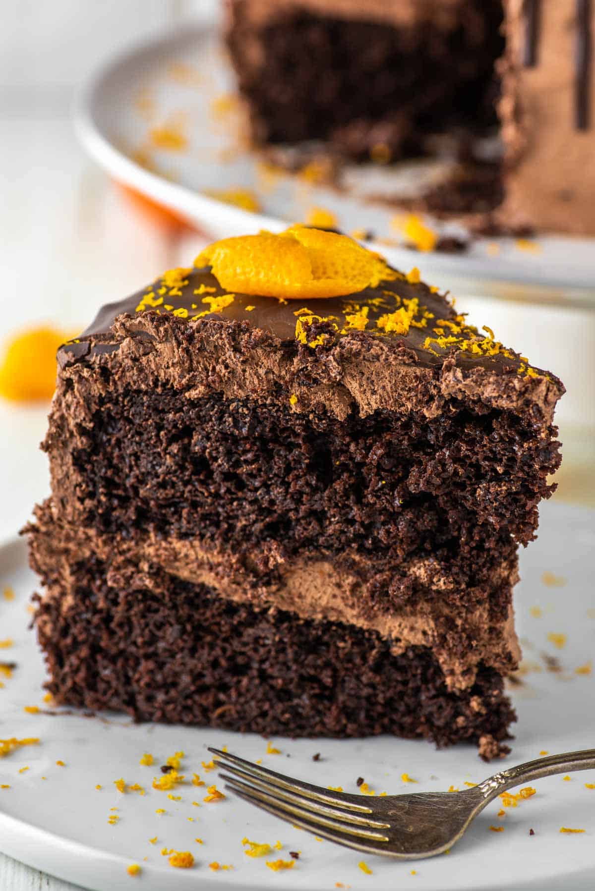 slice of chocolate orange cake on white plate with fork