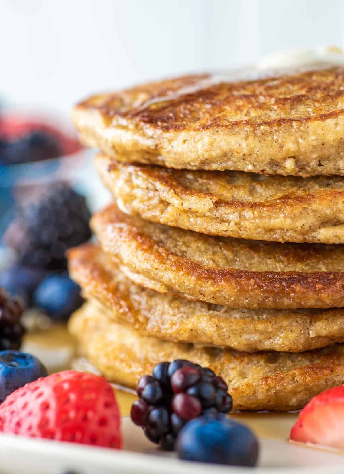 stacked pancakes with oat flour on plate and fruit