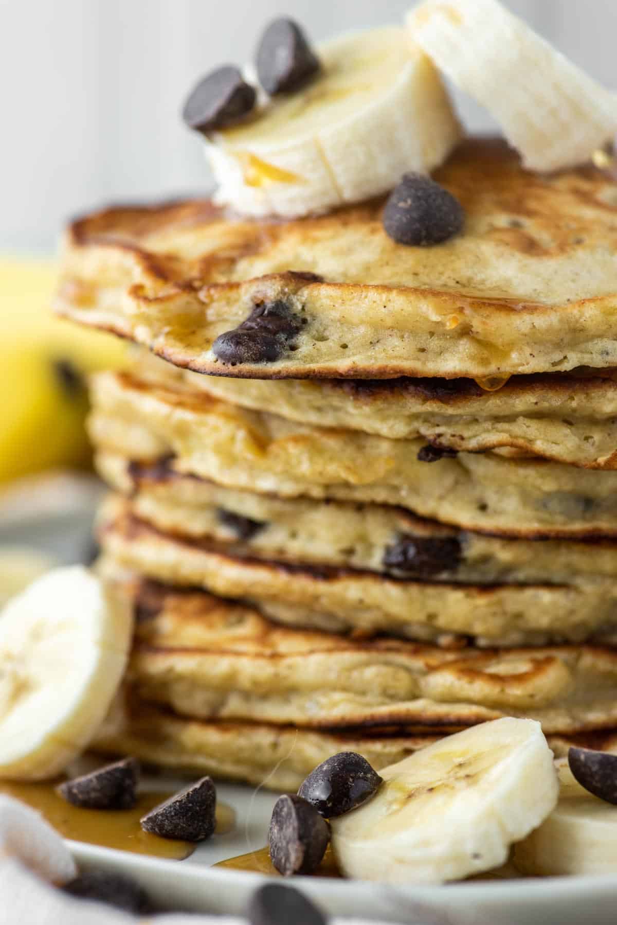 close-up of stacked banana chocolate chip pancakes on plate
