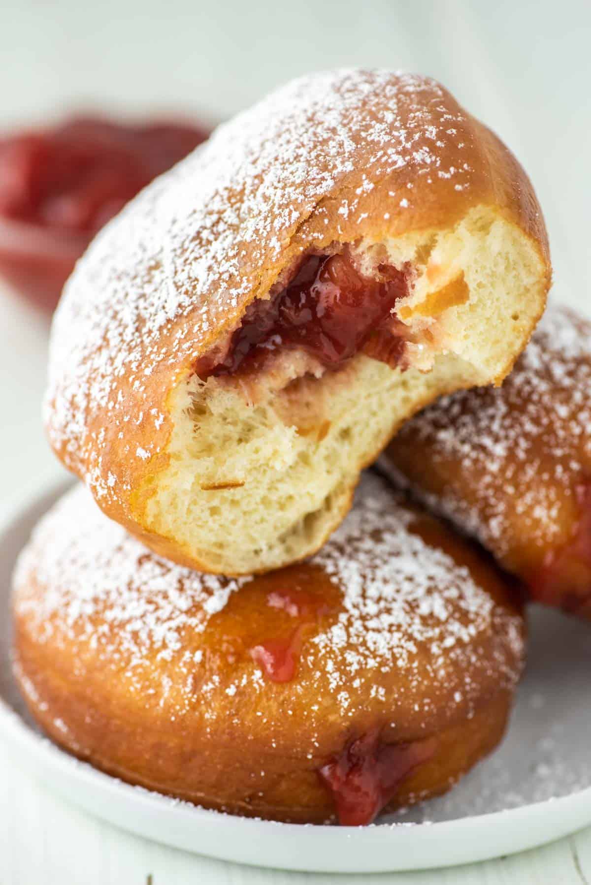berliner donut bitten in half and on top of other donuts