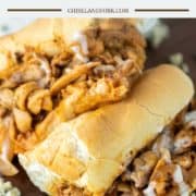 buffalo chicken cheesesteak cut in half and stacked on top of each on wood board