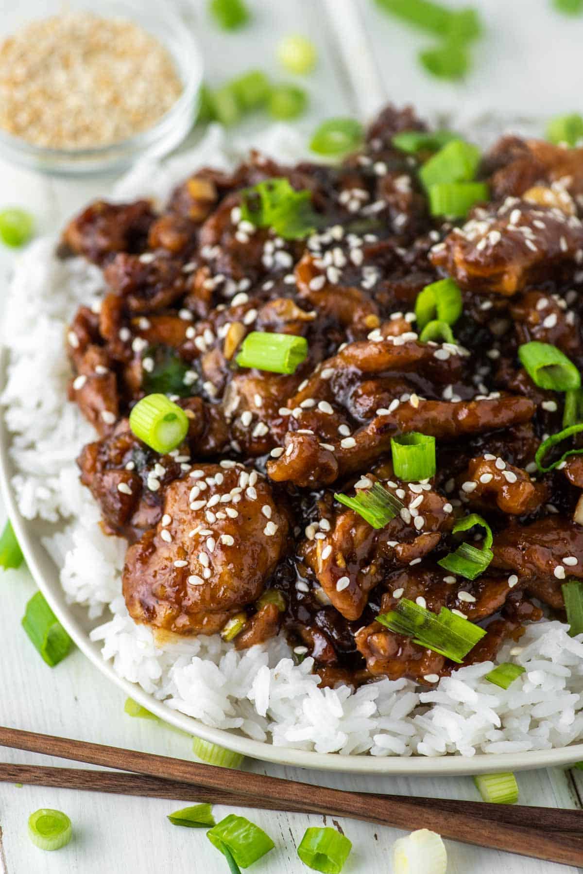close-up of pork tossed in sweet soy ginger garlic sauce on bed of white rice