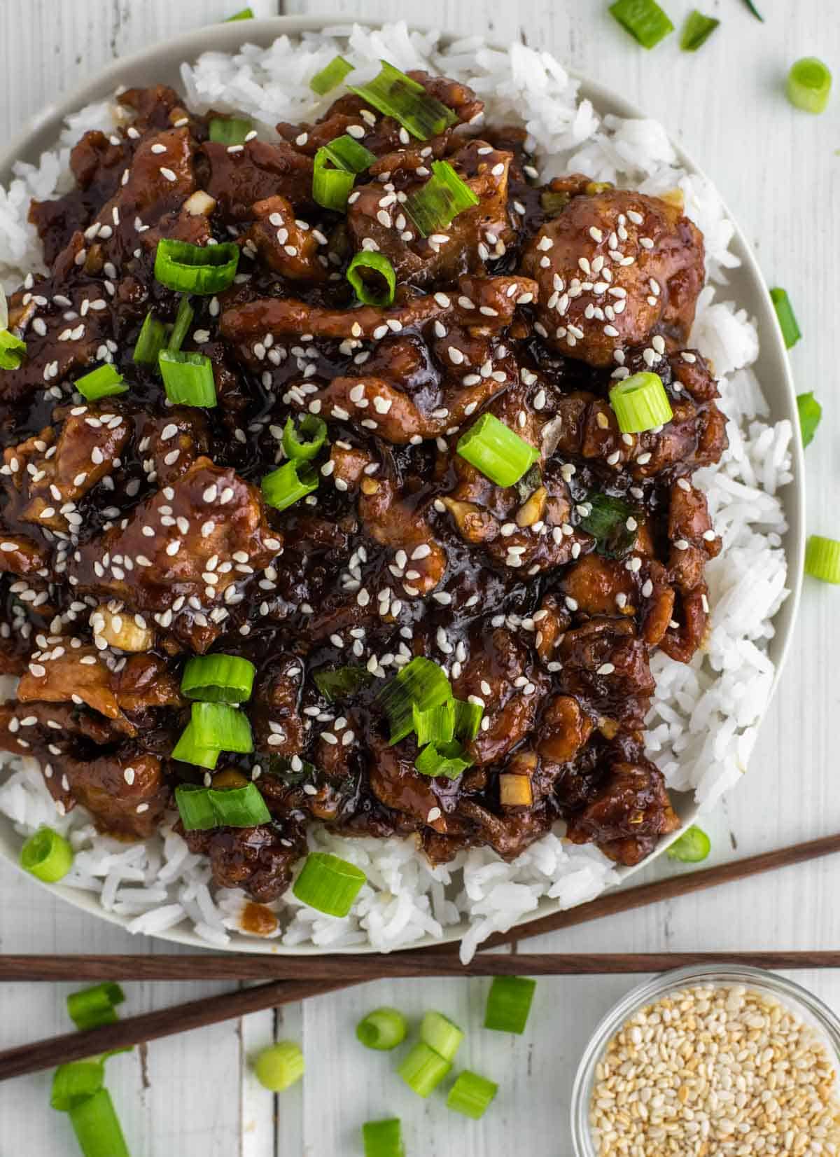 overhead shot of pork tossed in sweet soy ginger garlic sauce on bed of white rice