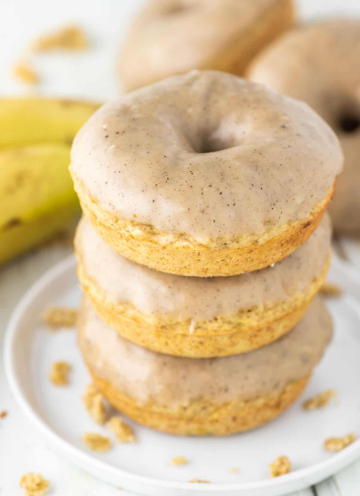 3 stacked banana donuts with brown butter glaze on plate