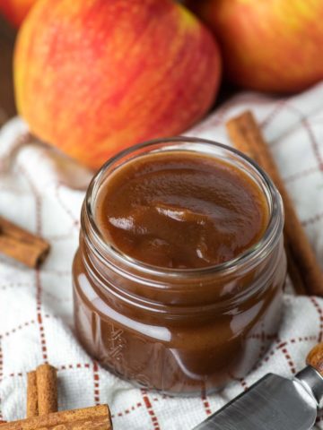 apple butter in glass jar on dish towel