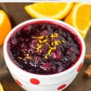 Instant Pot cranberry sauce in white bowl with oranges in background