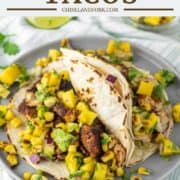 two rockfish tacos with corn mango salsa on grey plate