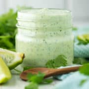 cilantro and garlic sauce in mason jar with spoon in front