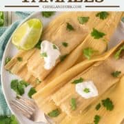 overhead shot of green chile chicken tamales on white plate with fork