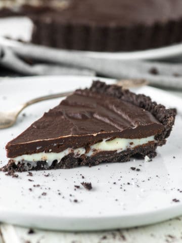 close-up of slice of Oreo tart on white plate with fork