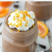 glass jar of chocolate orange mousse with whipped cream and orange zest on top