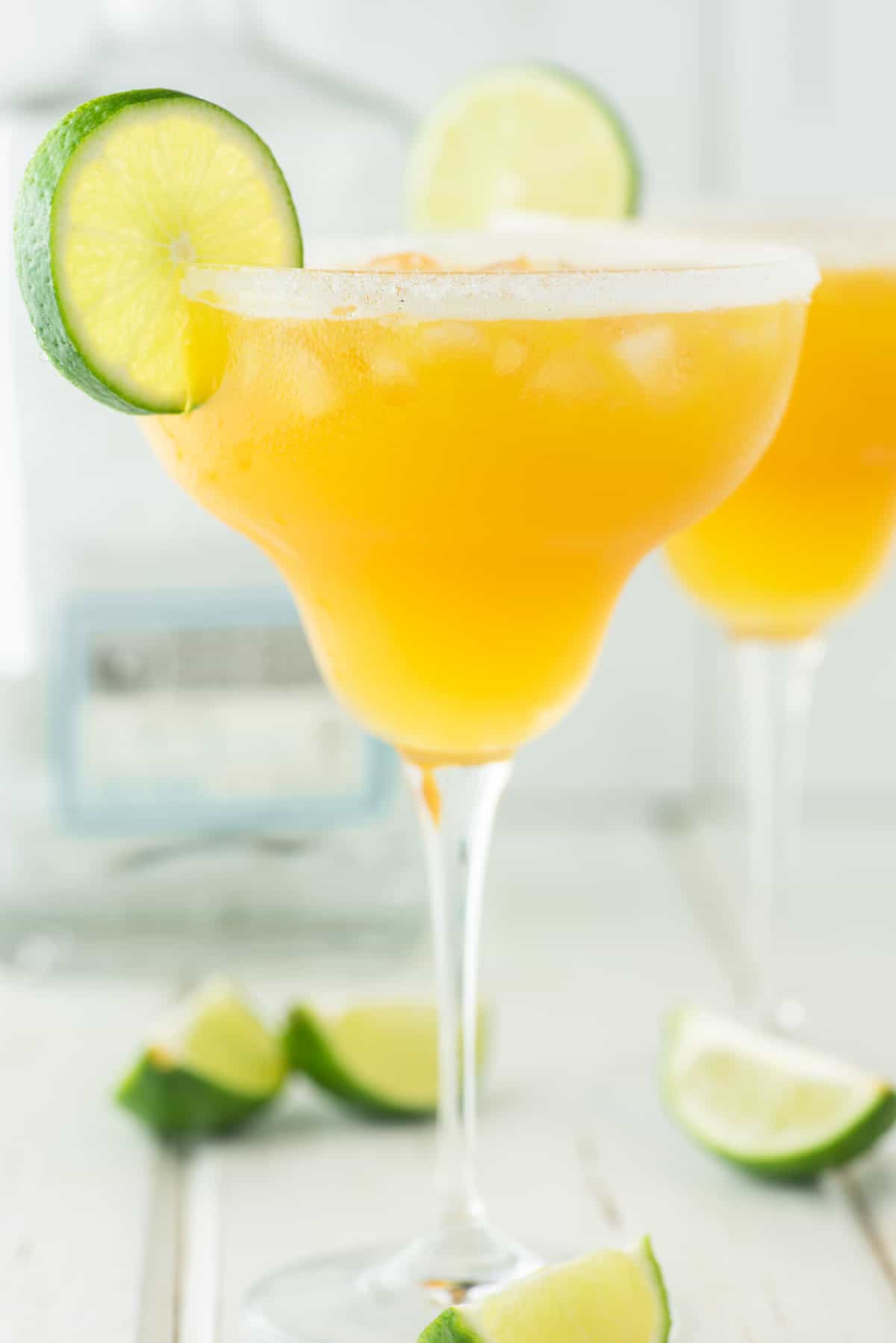 glass of passion fruit margarita with lime on rim