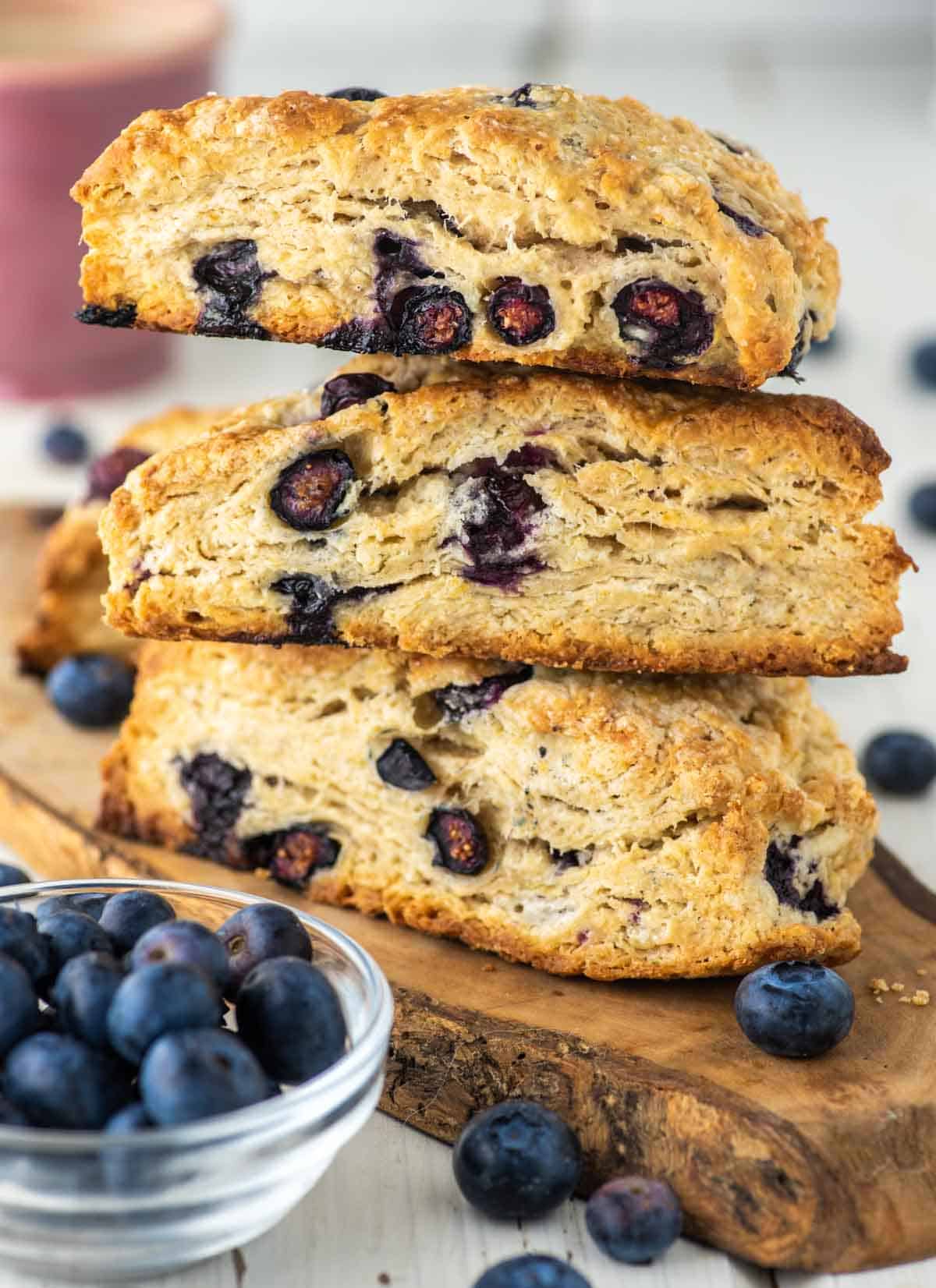 3 stacked blueberry scones on wood board