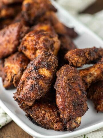 close-up of crispy smoked chicken wings on white plate