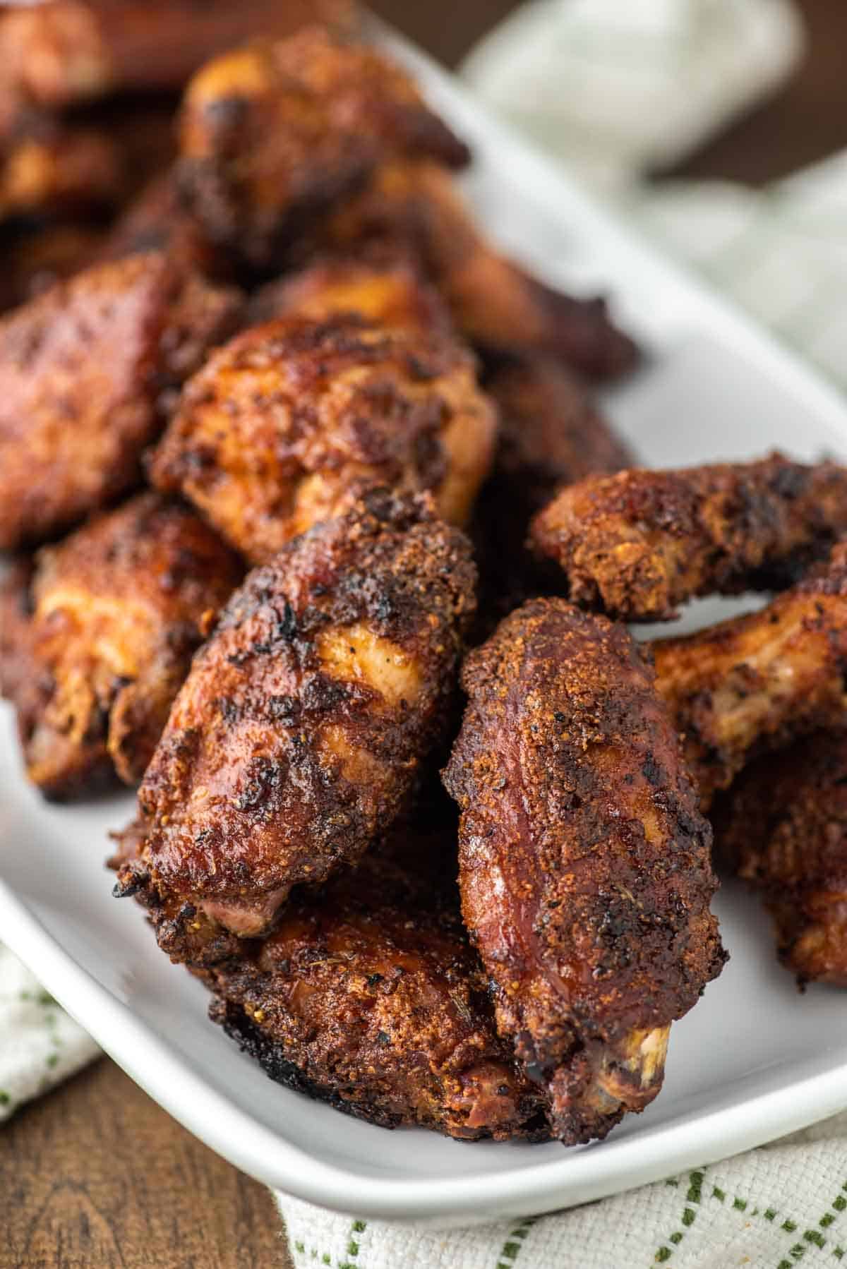 close-up of crispy smoked chicken wings on white plate