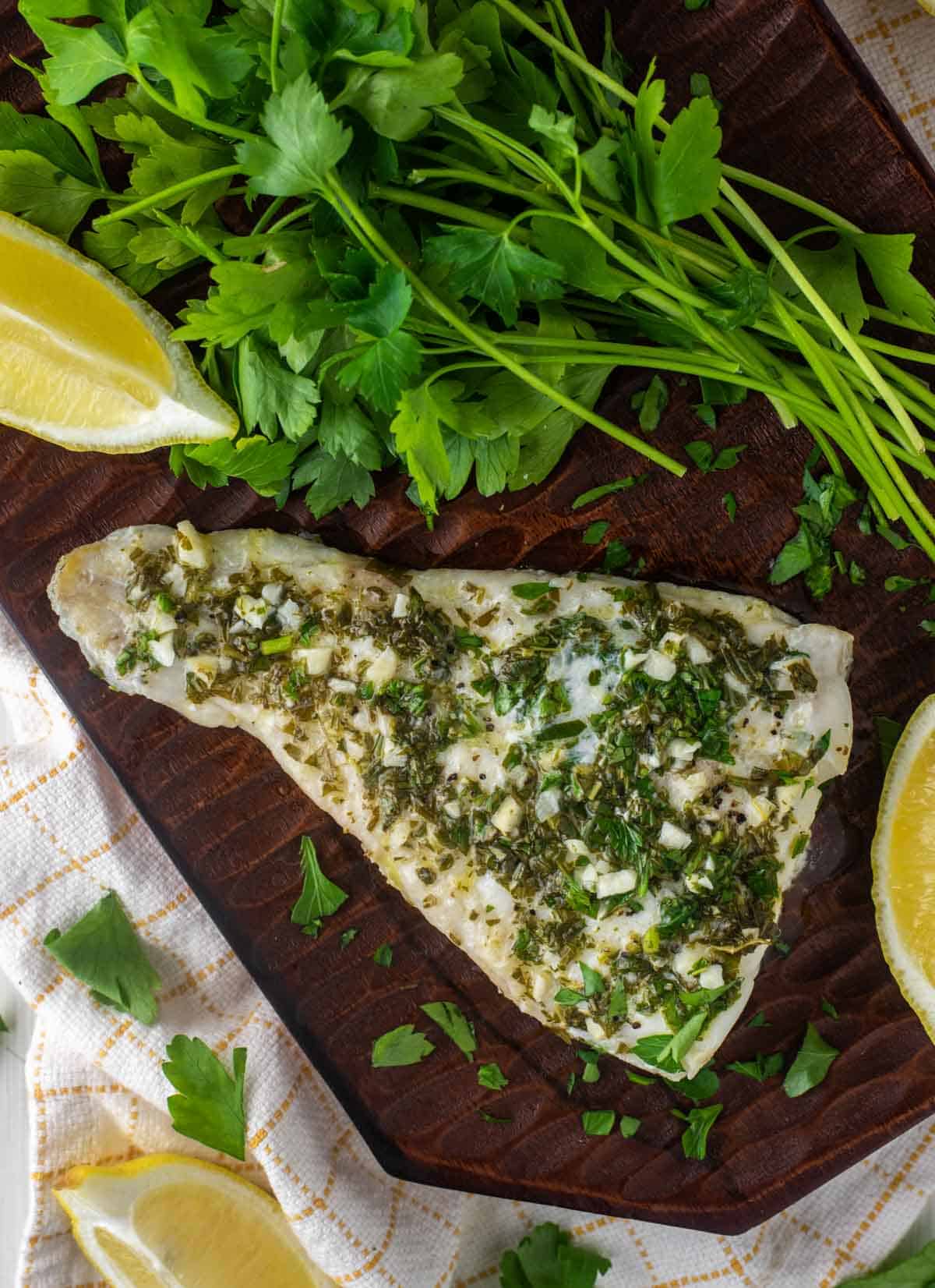 overhead shot of grilled haddock topped with lemon and herb sauce