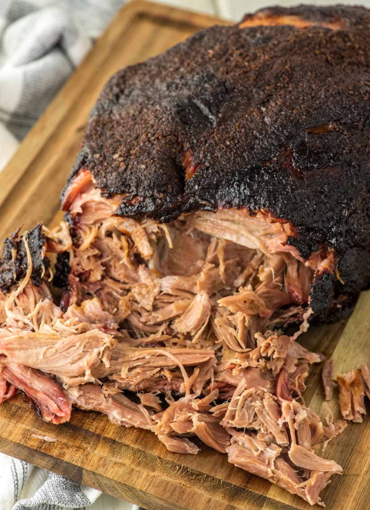 pulled pork pulled out from pork butt on cutting board