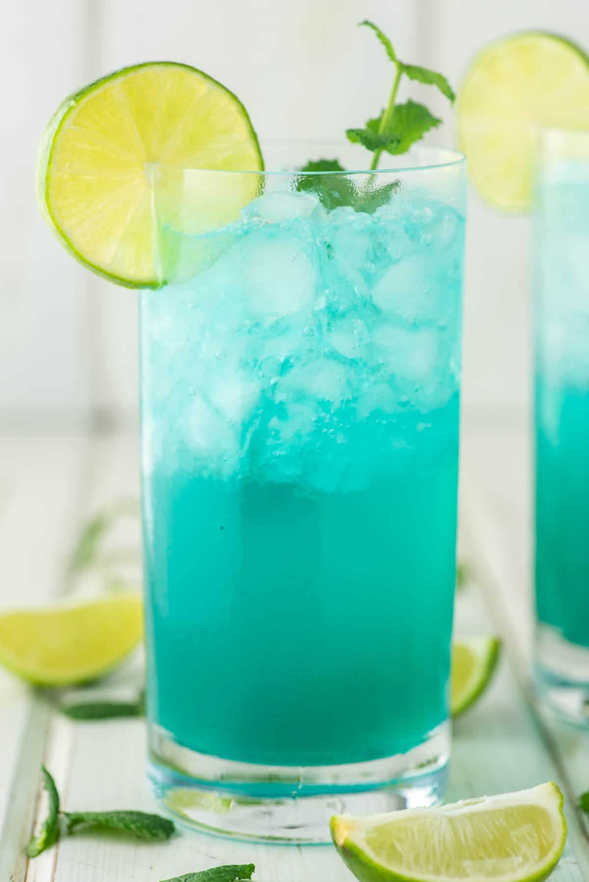 blue mojito in tall glass with lime and mint