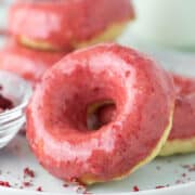 close-up of strawberry frosted donuts on white plate