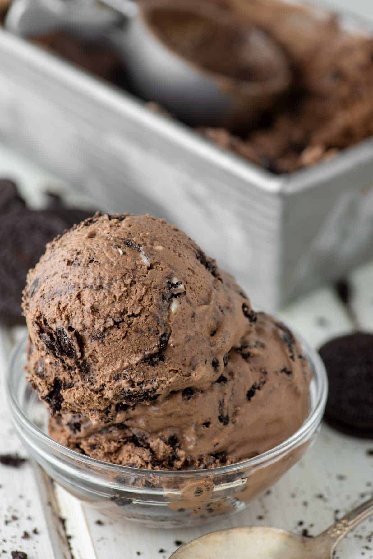 chocolate Oreo ice cream in bowl with metal tin in background